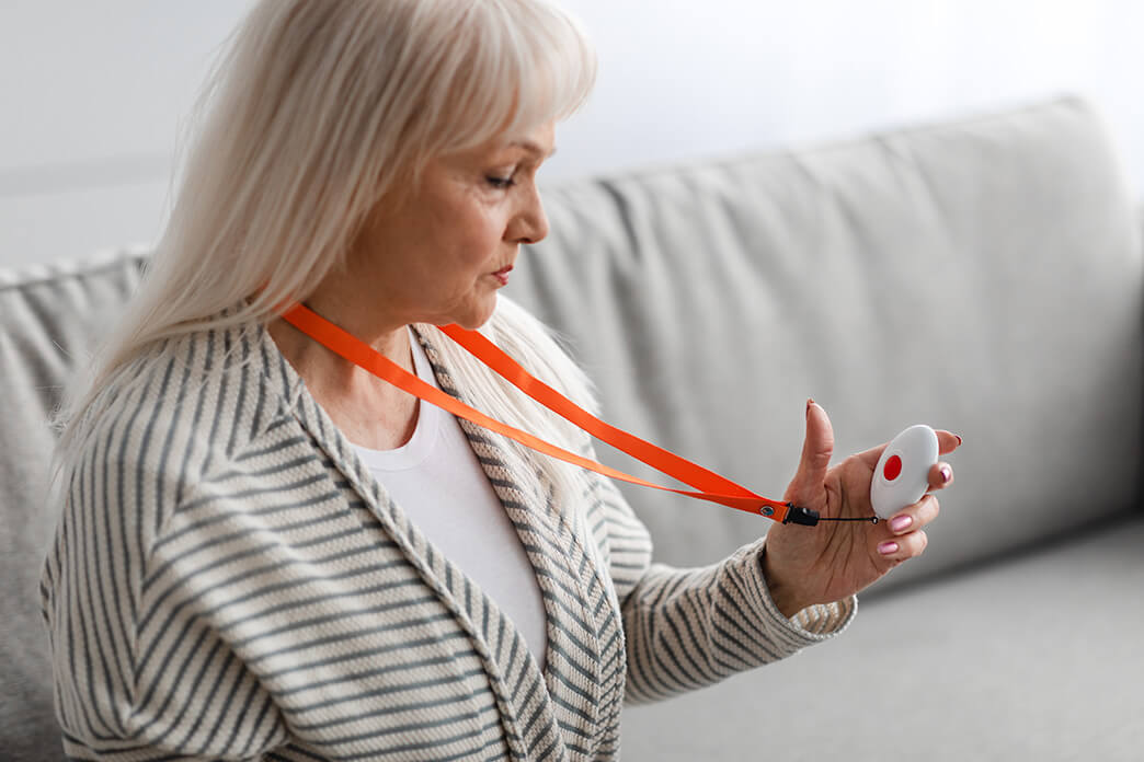 Seniorin mit Hausnotruf – der Notknopf befindet sich als Halskette stets in Reichweite