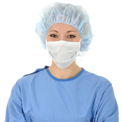 Ärztin trägt OP-Haube, OP-Maske und Kittel