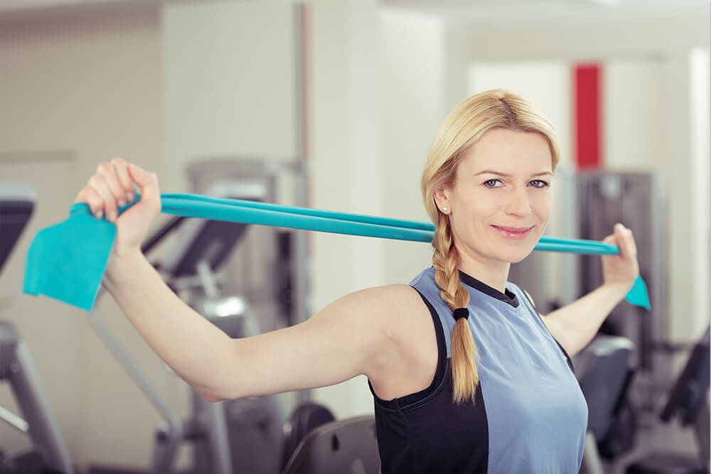 Eine Frau nutzt Therabänder für das Training
          Bildunterschrift: Therabänder sind flexibel einsetzbar.