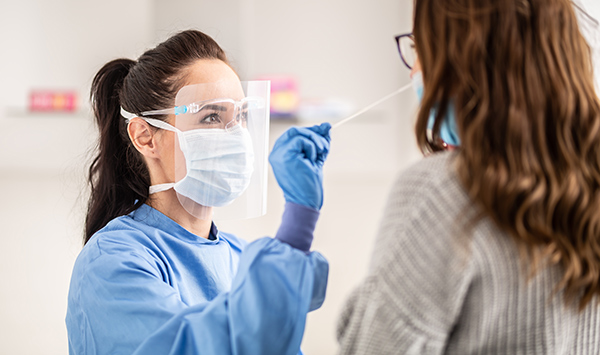 Eine Frau führt einen Corona PCR Test durch